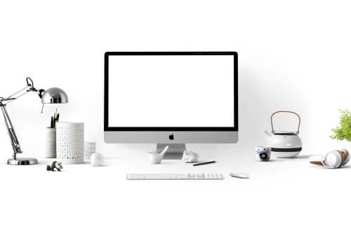 Mac book, home office, lamp, tea kettle, keyboard, and pens.
